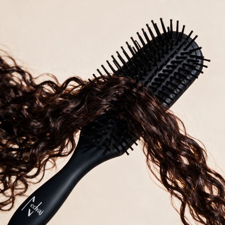 Brosse à cheveux noire avec des mèches de cheveux bouclés